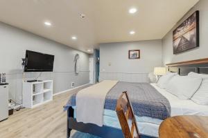 a bedroom with a large bed and a tv at Sea Treasures Inn #207 in Rockaway Beach