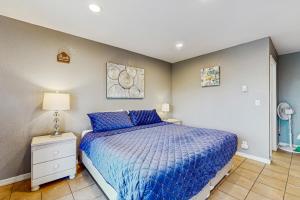 a bedroom with a bed with a blue comforter at Sea Treasures Inn #208 in Rockaway Beach