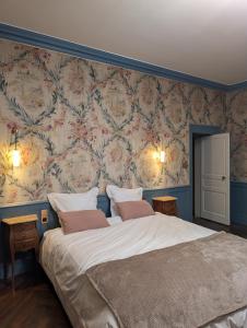 a bedroom with a large bed with floral wallpaper at Château du Mas de l'Âge in Couzeix +20 photos