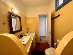 a bathroom with a sink and a mirror and a toilet at Sea View Cycladic Home in Santa Maria
