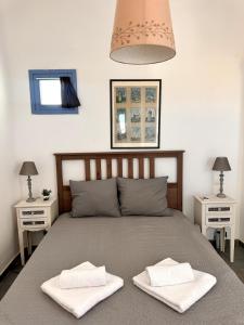 a bedroom with a bed with two white towels on it at Sea View Cycladic Home in Santa Maria