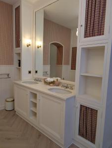 a bathroom with two sinks and a large mirror at Château du Mas de l'Âge in Couzeix
