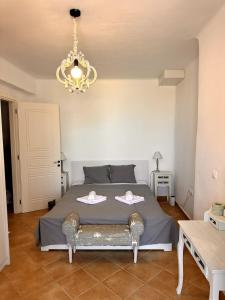 a bedroom with a large bed with a chandelier at Sea View Cycladic Home in Santa Maria +45 photos