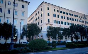 a large white building next to a street at VelaMar in Trieste +9 photos
