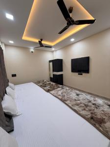 a room with a bed and a ceiling fan at Hotel Shivlok Inn in Ujjain