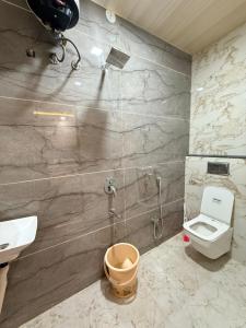 a bathroom with a shower and a toilet and a sink at Hotel Shivlok Inn in Ujjain