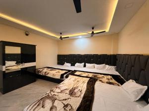 a bedroom with two beds and a mirror at Hotel Shivlok Inn in Ujjain