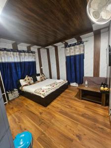 a bedroom with a bed in a room with blue curtains at The sameer resort in Anantnāg