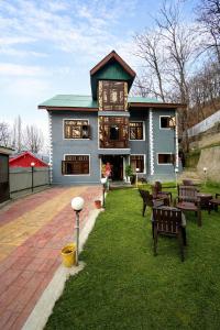 a large house with benches in front of it at The sameer resort in Anantnāg
