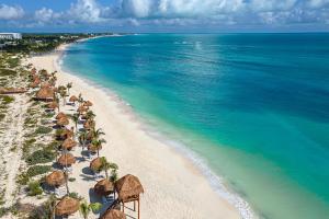 a beach with umbrellas and chairs and the ocean at Ocean Allure Costa Mujeres - Adults Only - All Inclusive in Costa Mujeres