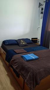 a bedroom with two beds with blue pillows on them at Pousada e Camping Caldeirão Furado in São Thomé das Letras +58 photos
