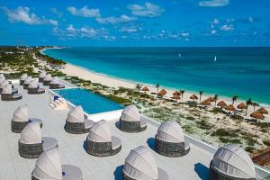 a resort with a pool and a beach with umbrellas at Ocean Allure Costa Mujeres - Adults Only - All Inclusive in Costa Mujeres