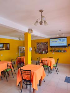 a dining room with orange tables and chairs at Sumaq Samay in San Antonio de los Cobres