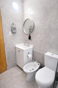 a bathroom with a toilet and a sink and a mirror at Aura Apart in Reconquista +11 photos