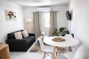 a living room with a white table and a black couch at Aura Apart in Reconquista