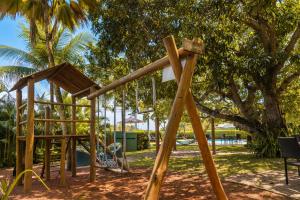 a playground in a park with a wooden structure at Pousada Villa Maeva Itacimirim in Itacimirim