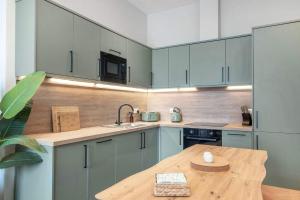 a kitchen with blue cabinets and a wooden table at The Sauchie in Glasgow