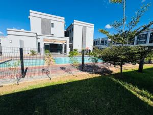 a fence with a pool in front of a building at Habitat Kappa Alexio in Gaborone