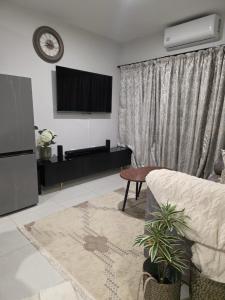 a living room with a flat screen tv and a couch at Habitat Kappa Alexio in Gaborone