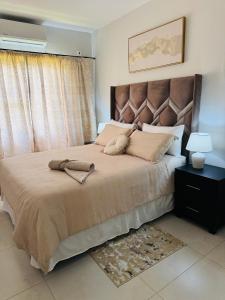 a bedroom with a large bed with a large headboard at Habitat Kappa Alexio in Gaborone +16 photos