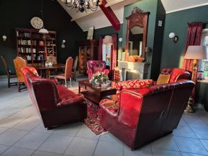 a living room with red furniture and a fireplace at Gastenverblijf de Bloesem privé appartement in Lunteren