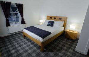 a bedroom with a bed and two lamps and a window at Adderley House B&B in Pitlochry