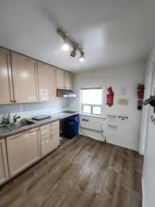 a kitchen with white cabinets and a wooden floor at Affordable Quiet Private Room - 10-min Walk to Subway in Toronto