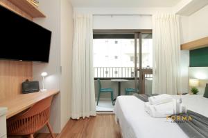 a bedroom with a bed and a desk with a television at Raízes Studios Tatuapé – Mitre 4 in São Paulo