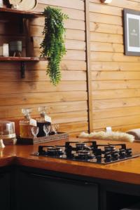 a stove top in a kitchen with a wooden wall at Chalé Mont Valle in Bom Jardim da Serra +11 photos