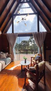 a living room with a large window and a couch at Chalé Mont Valle in Bom Jardim da Serra
