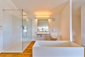a large white bath tub in a bathroom with a shower at Villa Bambou bei Cannes mit Blick auf Cap Antibes in Vallauris