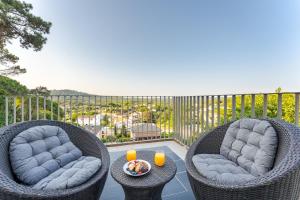 two wicker chairs and a table on a balcony at Piscina & BBQ | Cerca Costa Brava in Tordera