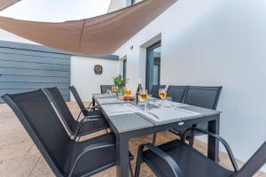 a table with chairs and wine glasses on a patio at Piscina & BBQ | Cerca Costa Brava in Tordera
