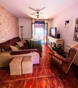 a living room with a couch and a tv at Casona El Chaparral in Fondón