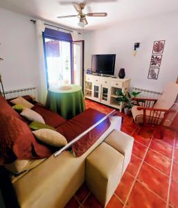 a living room with a couch and a tv at Casona El Chaparral in Fondón