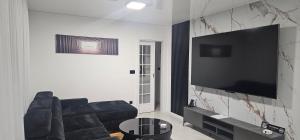 a living room with a couch and a flat screen tv at Luxury Villa JAKOV in Banja Luka