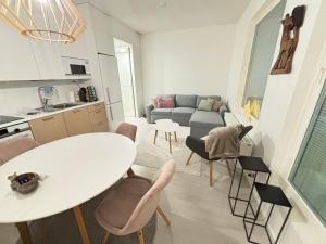 a kitchen and a living room with a table and chairs at Metsämansikan helmi I Free parking & Netflix I 5G in Espoo