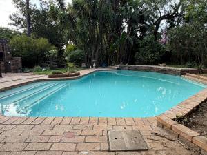 a swimming pool with blue water in a yard at 55 Albatross B&B in Sandton