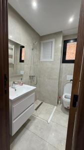 a bathroom with a sink and a shower and a toilet at La perle in Sukrah