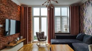 a living room with a couch and a brick wall at !! VIP Apartament Pod BIESZCZADAMI !! in Sanok