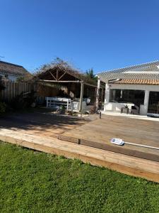 a backyard with a wooden deck in front of a house at Vila Brisa do Mar in Comporta