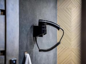 a black blow dryer on a wall in a bathroom at Rusiński Raj - Domki in Bukowina Tatrzańska