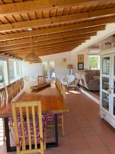 a kitchen and living room with a wooden table and chairs at Vila Brisa do Mar in Comporta
