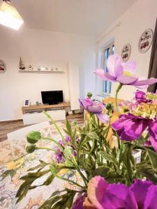 a room with purple flowers on a table at Le Case di Ciccine' in Bagheria
