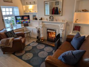 a living room with couches and a fireplace at Widows Row Cottage in Newcastle