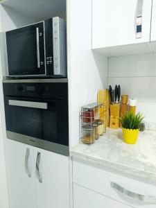 a kitchen with a microwave above a stove at La Joie Al Jadid in Nador