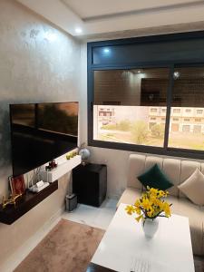 a living room with a couch and a large window at La Joie Al Jadid in Nador