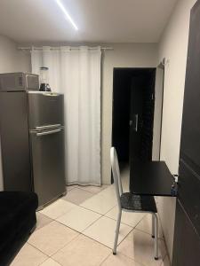eine Küche mit Tisch, Stuhl und Kühlschrank in der Unterkunft apt 112 in Teresina
