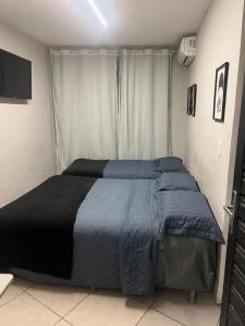 ein Schlafzimmer mit einem Bett mit blauer Bettdecke in der Unterkunft apt 112 in Teresina