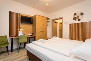 a bedroom with two beds and a desk and a television at Conco Leipzig in Leipzig